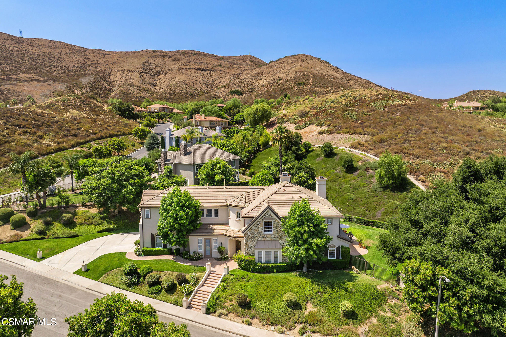 an aerial view of residential houses with outdoor space and trees