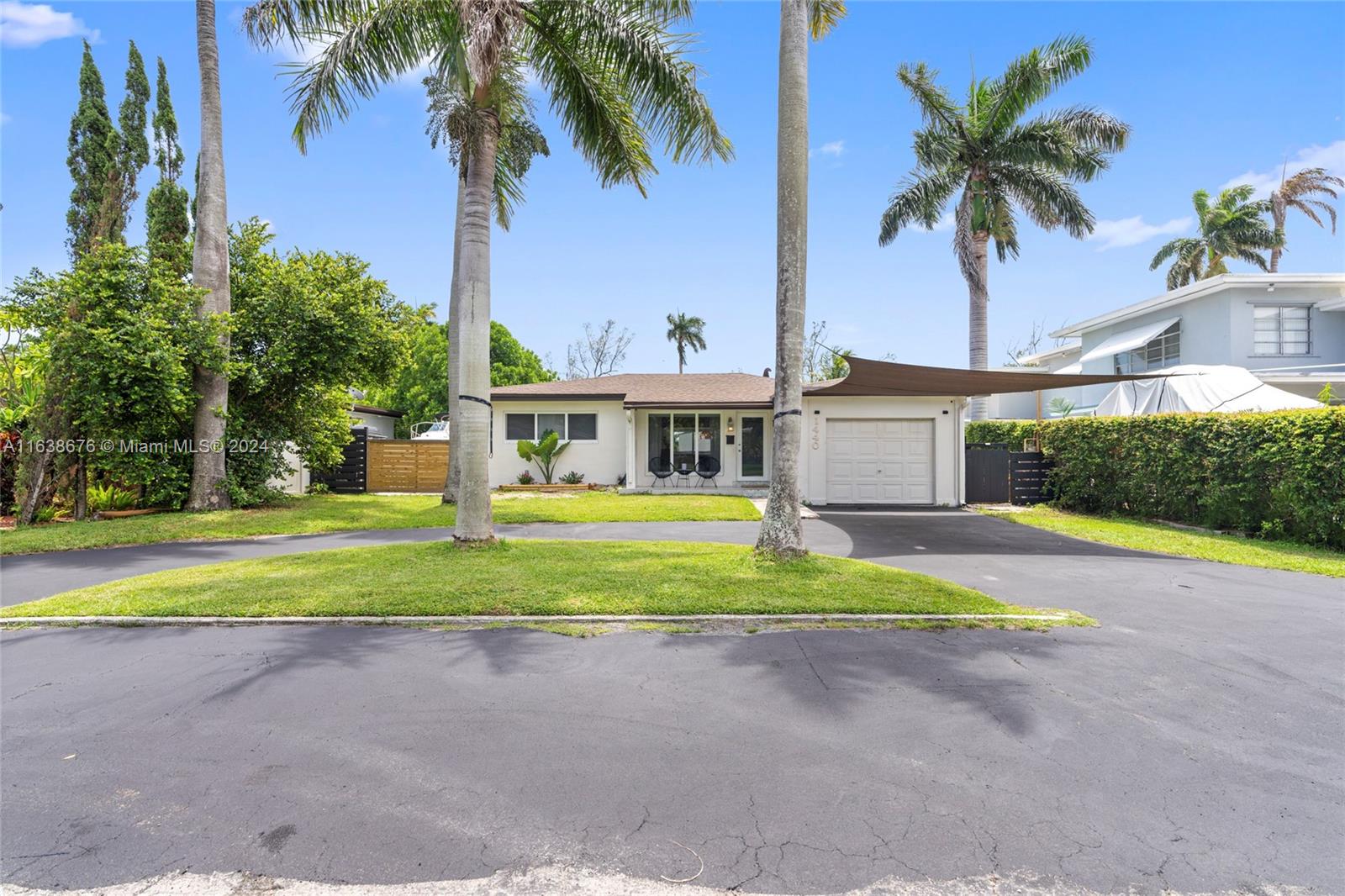 a view of a house with a yard and palm trees