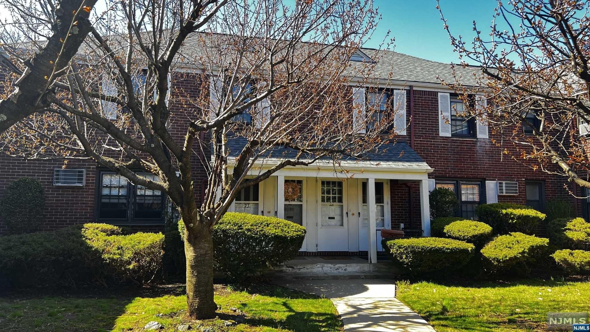 a front view of a house with a yard and fountain in middle