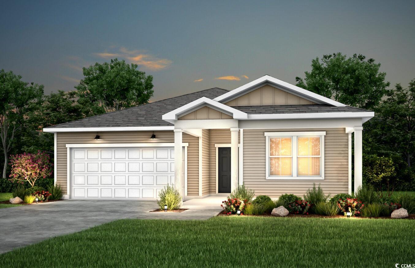 View of front facade featuring a yard and a garage