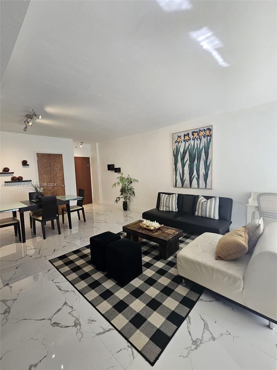 a living room with furniture a rug and white walls