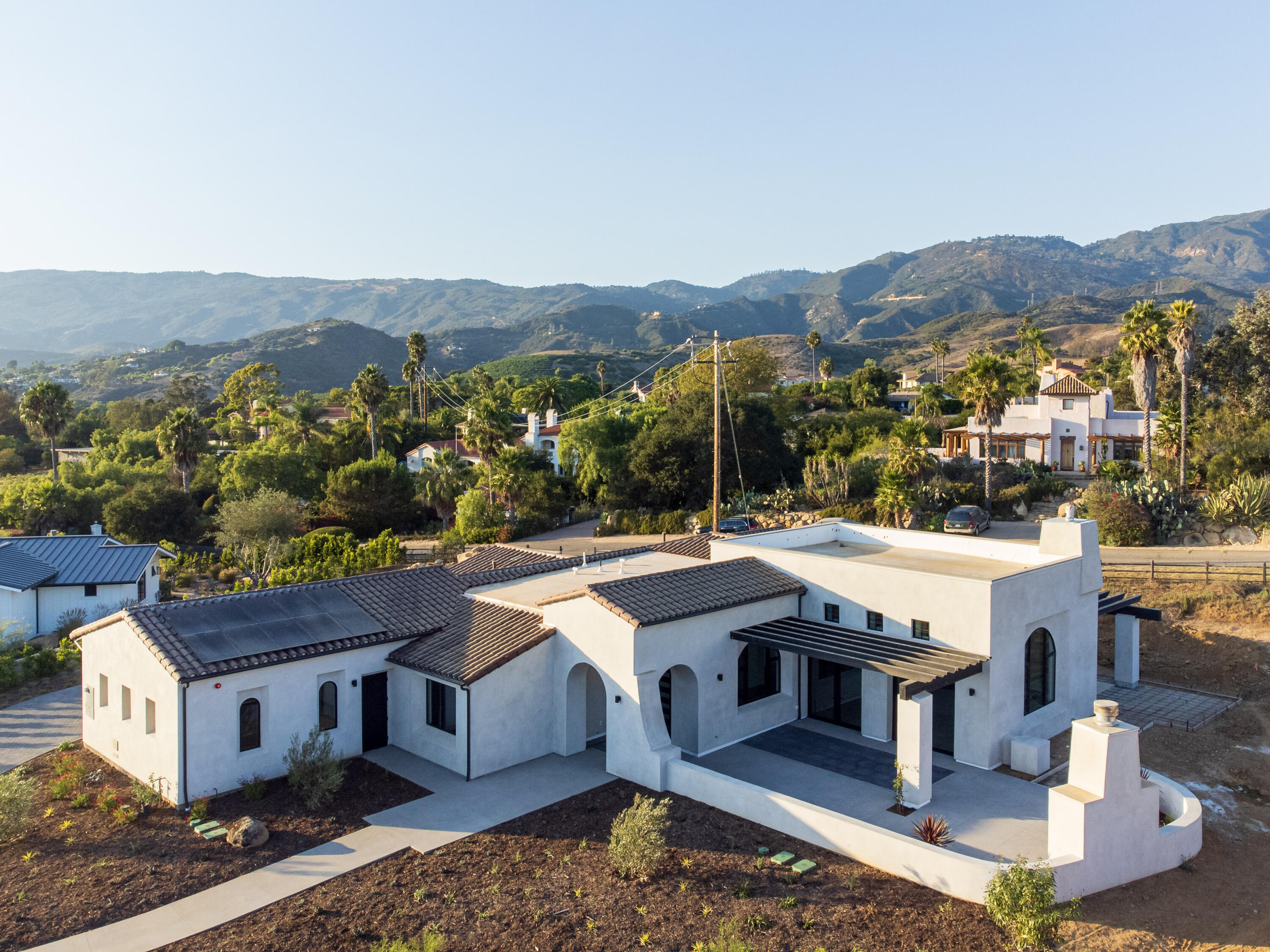 an aerial view of a house with a yard and mountain view