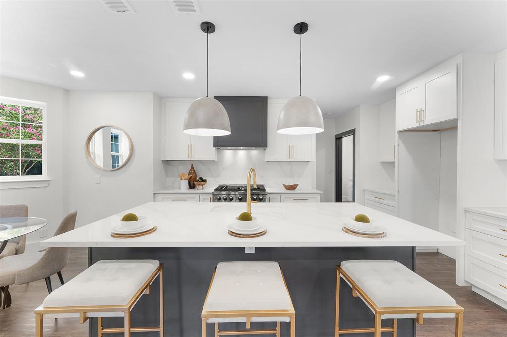 a kitchen with a dining table chairs and white cabinets