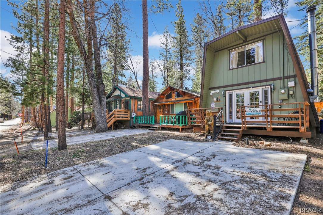 a view of house with outdoor space and tall trees