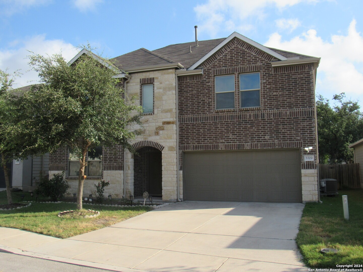 a front view of a house with a garden and garage