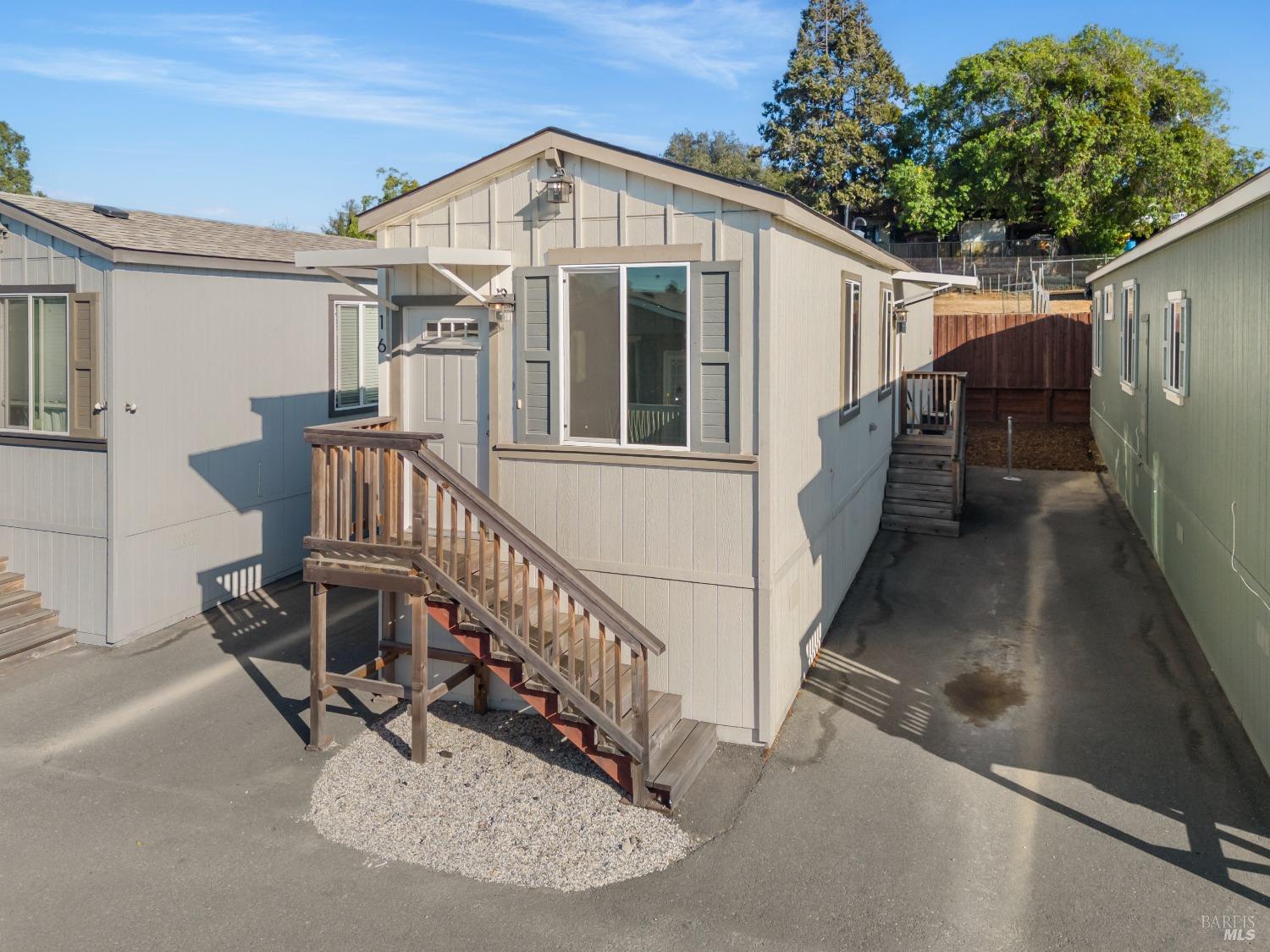 a view of a house with wooden deck front of house