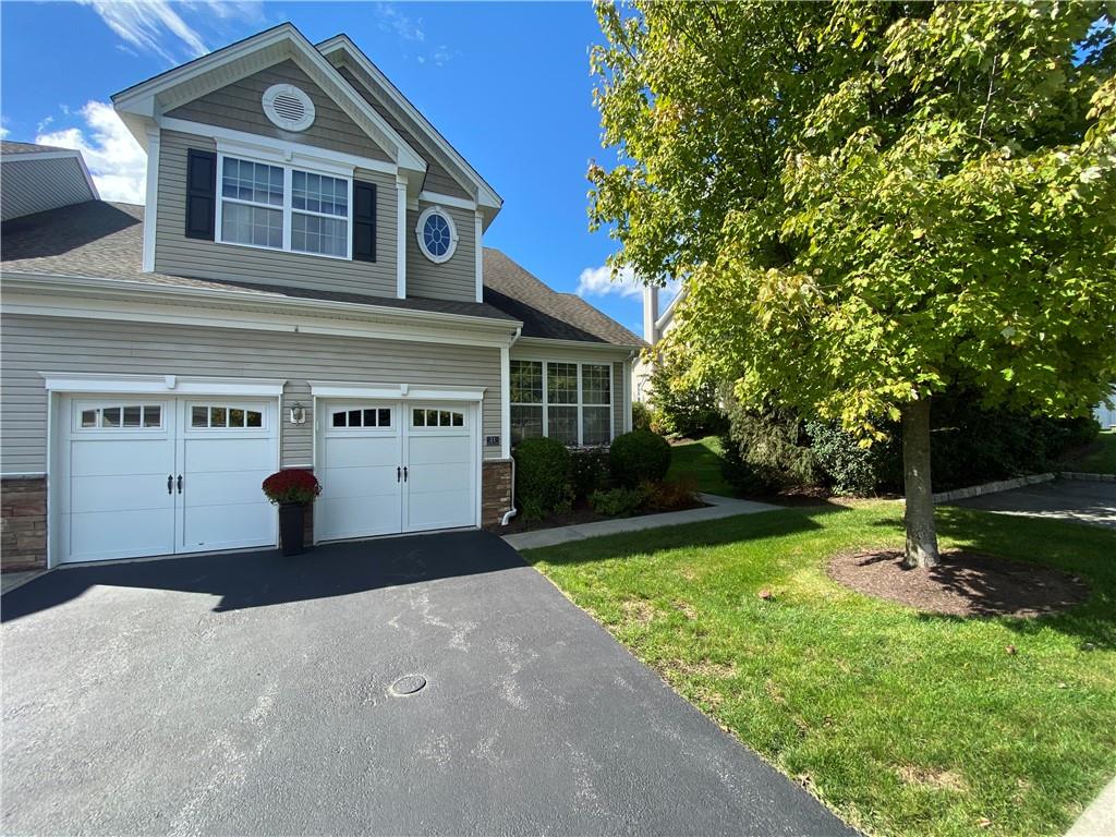 View of front facade featuring a front lawn and a garage