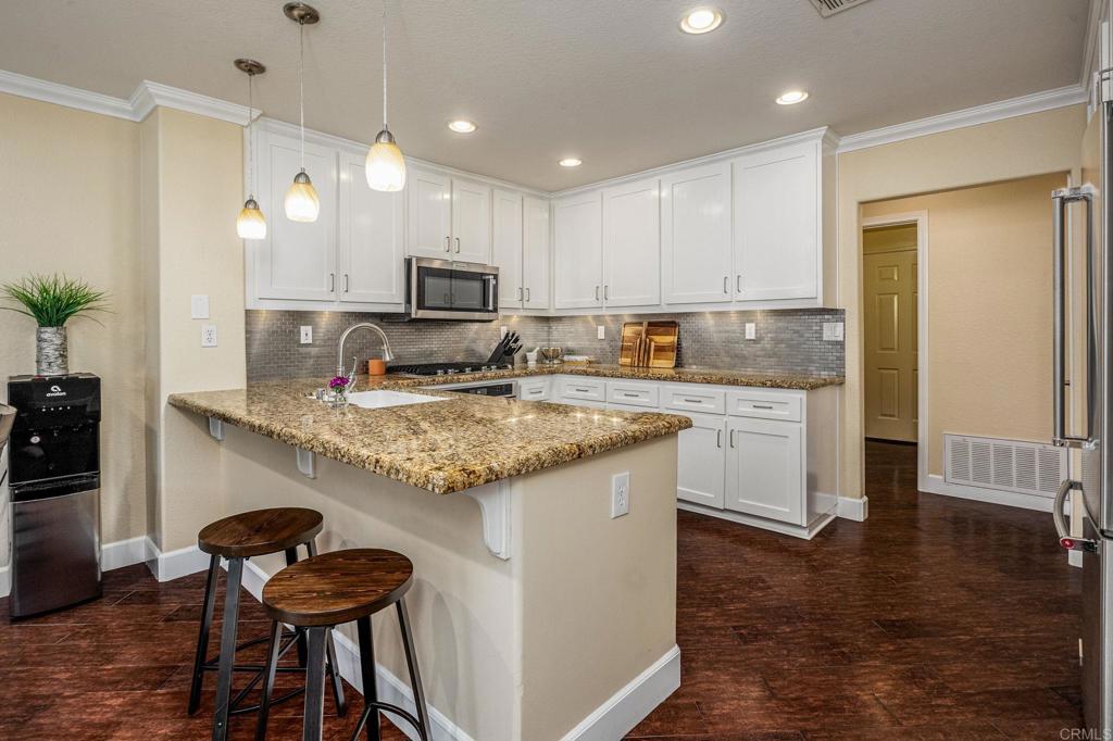 a kitchen with kitchen island granite countertop wooden cabinets and a refrigerator