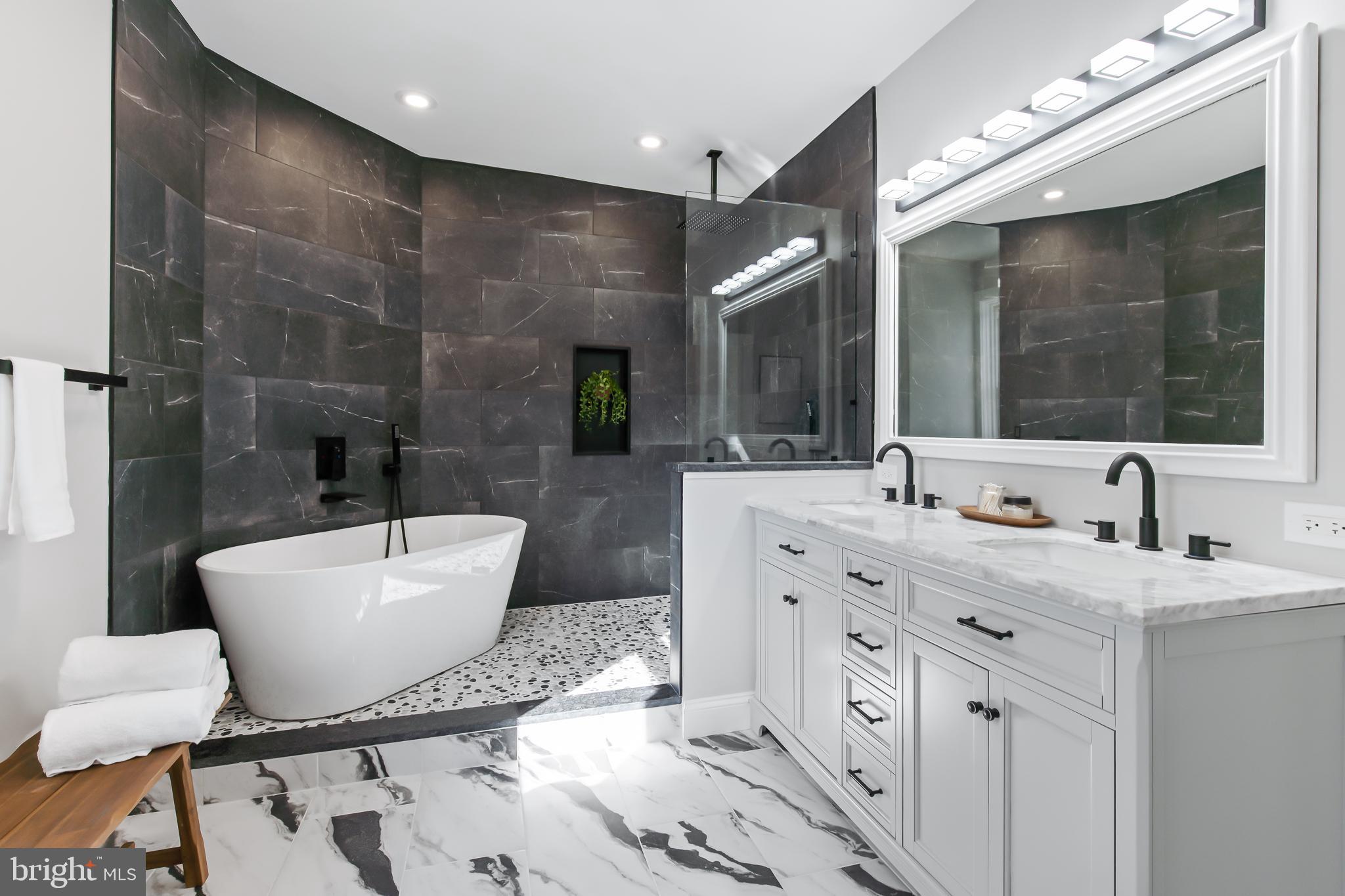 a bathroom with a double vanity sink mirror and bathtub