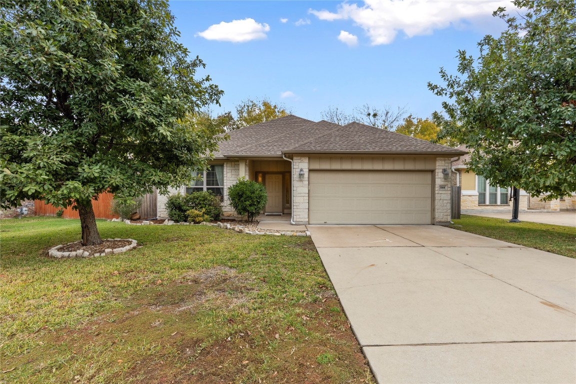 a front view of a house with a yard and trees