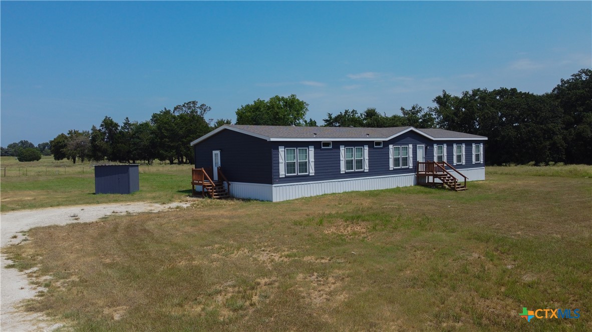 a view of a house with a yard and sitting area