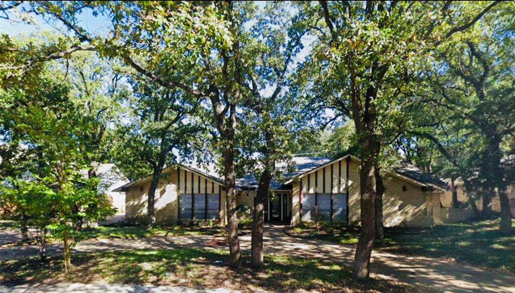 a front view of a house with a tree