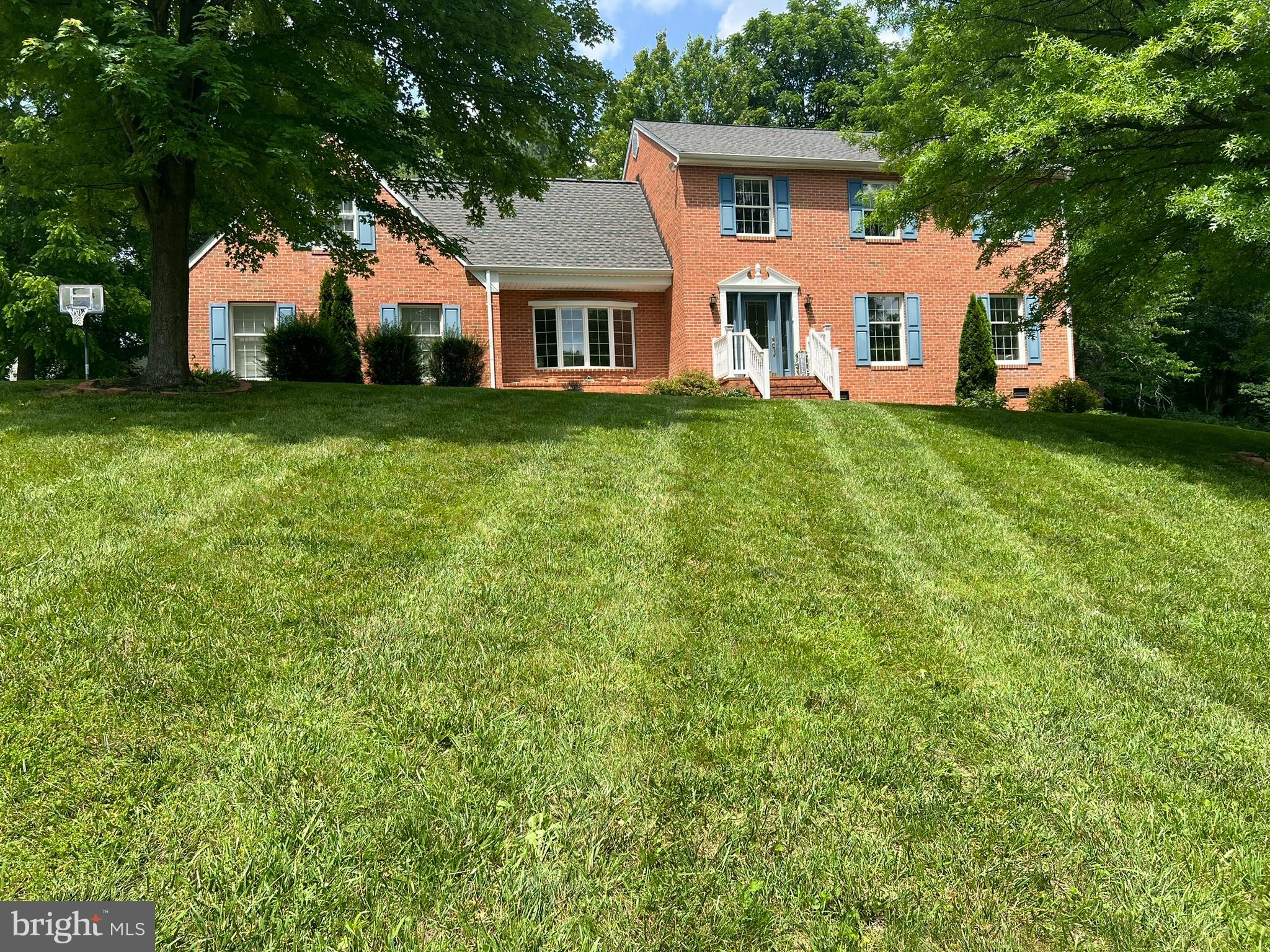 a front view of a house with a yard and trees