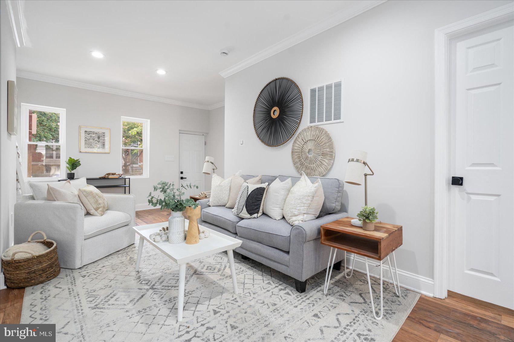 a living room with furniture a rug and wooden floor