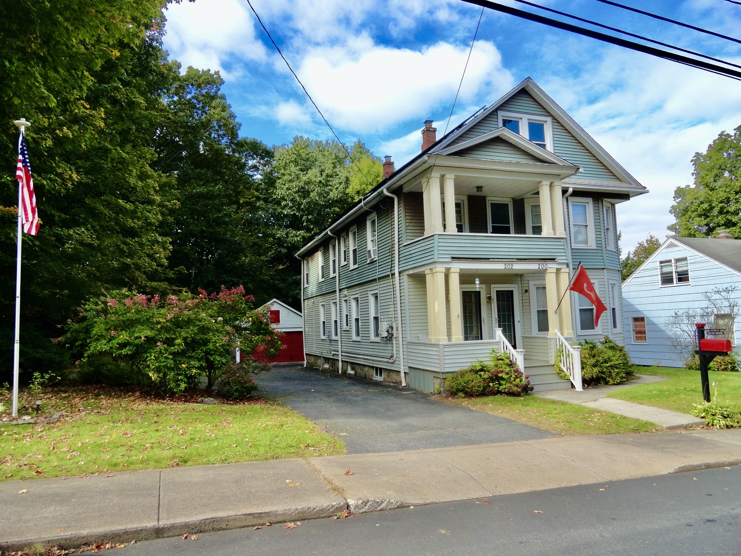 a front view of a house with a yard and potted plants