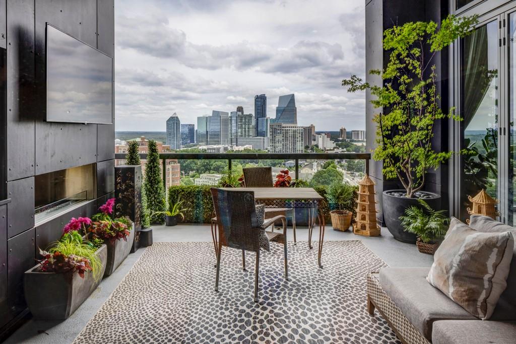 a living room with furniture a potted plant and outdoor seating