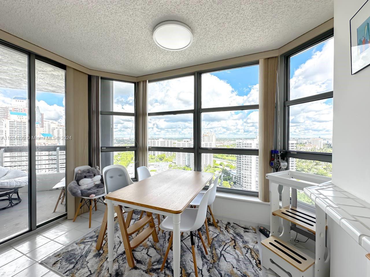 a view of a dining room with furniture large windows and wooden floor