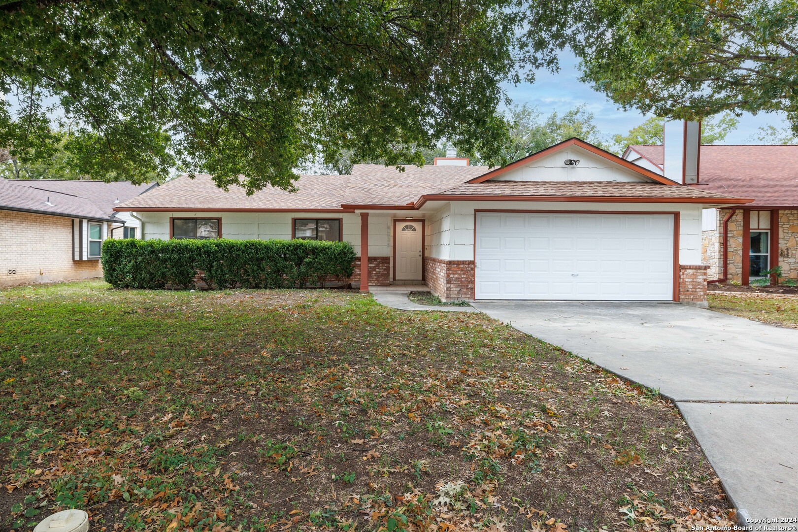 a front view of a house with a yard and trees