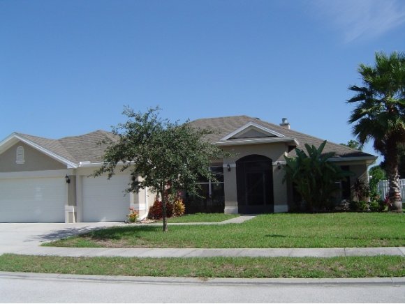 a view of a house with a yard and large tree