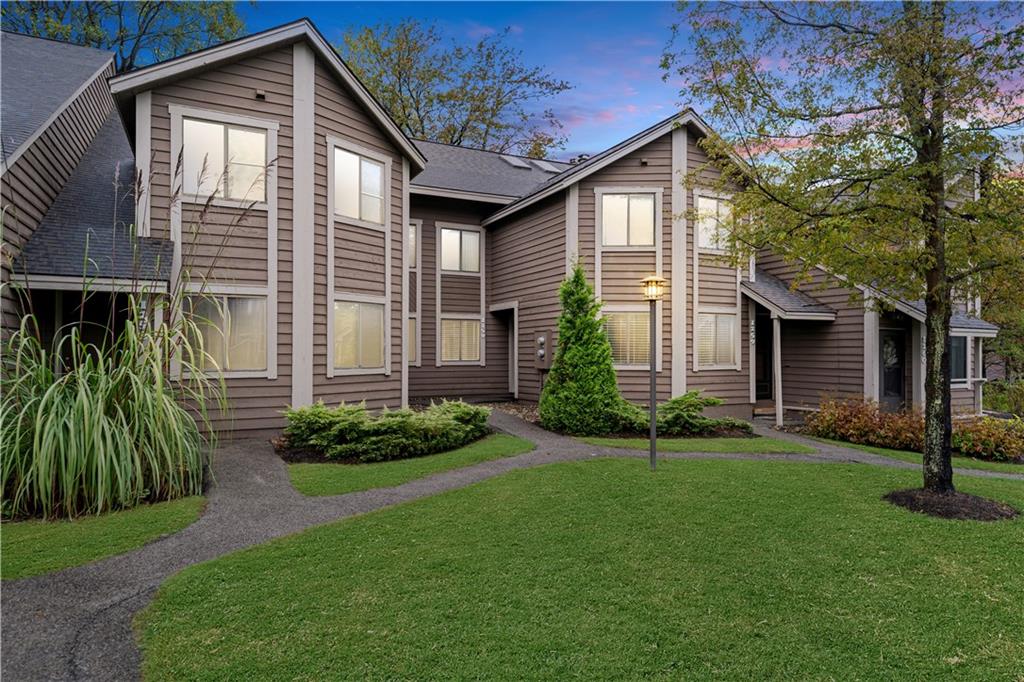 a front view of a house with a yard and plants