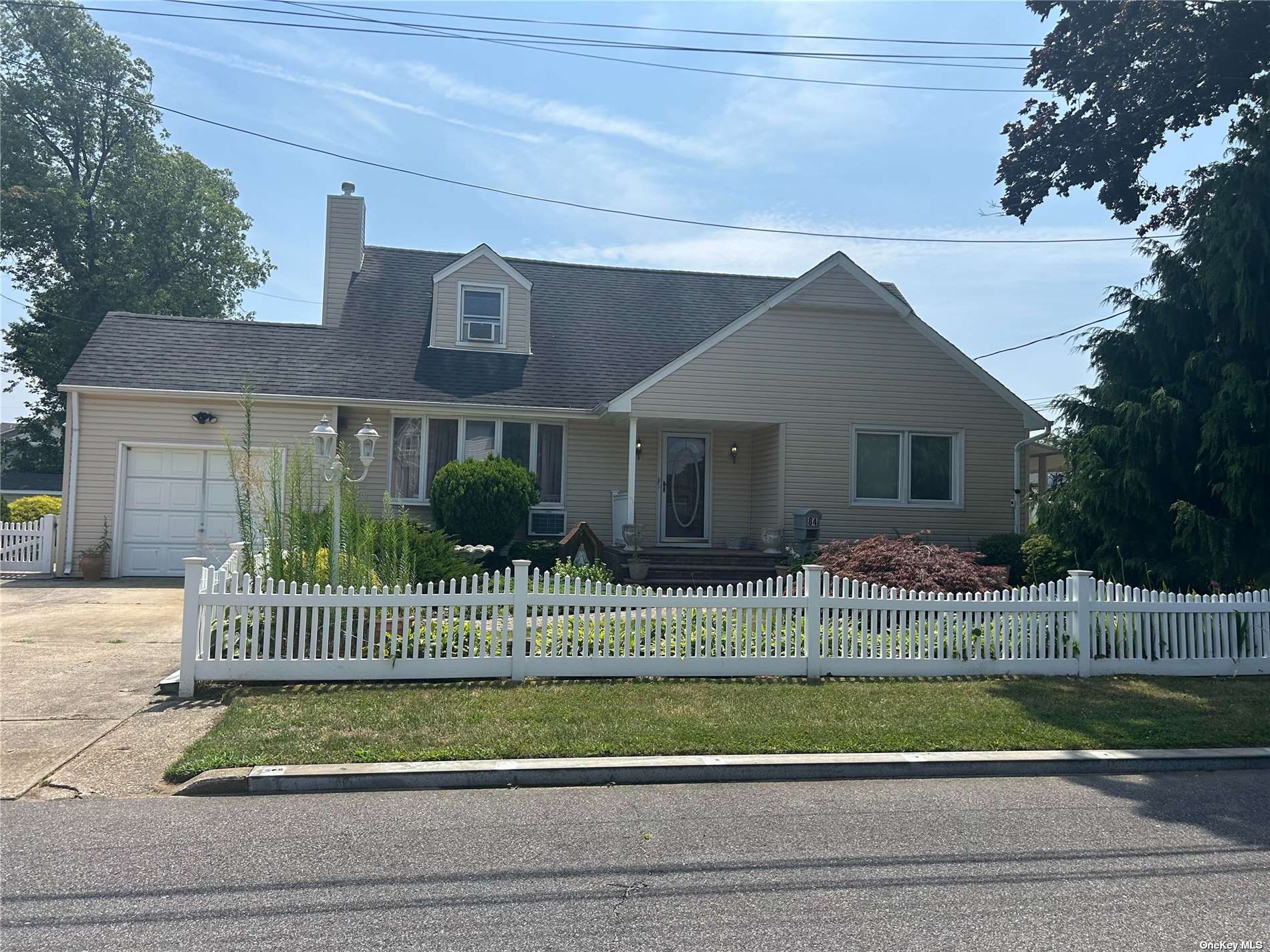 a view of a house with a small yard plants and large tree