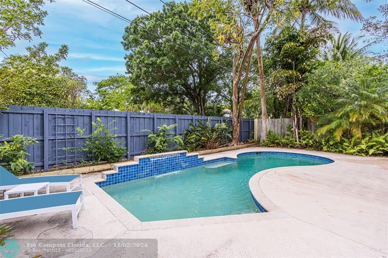 a view of a backyard with swimming pool