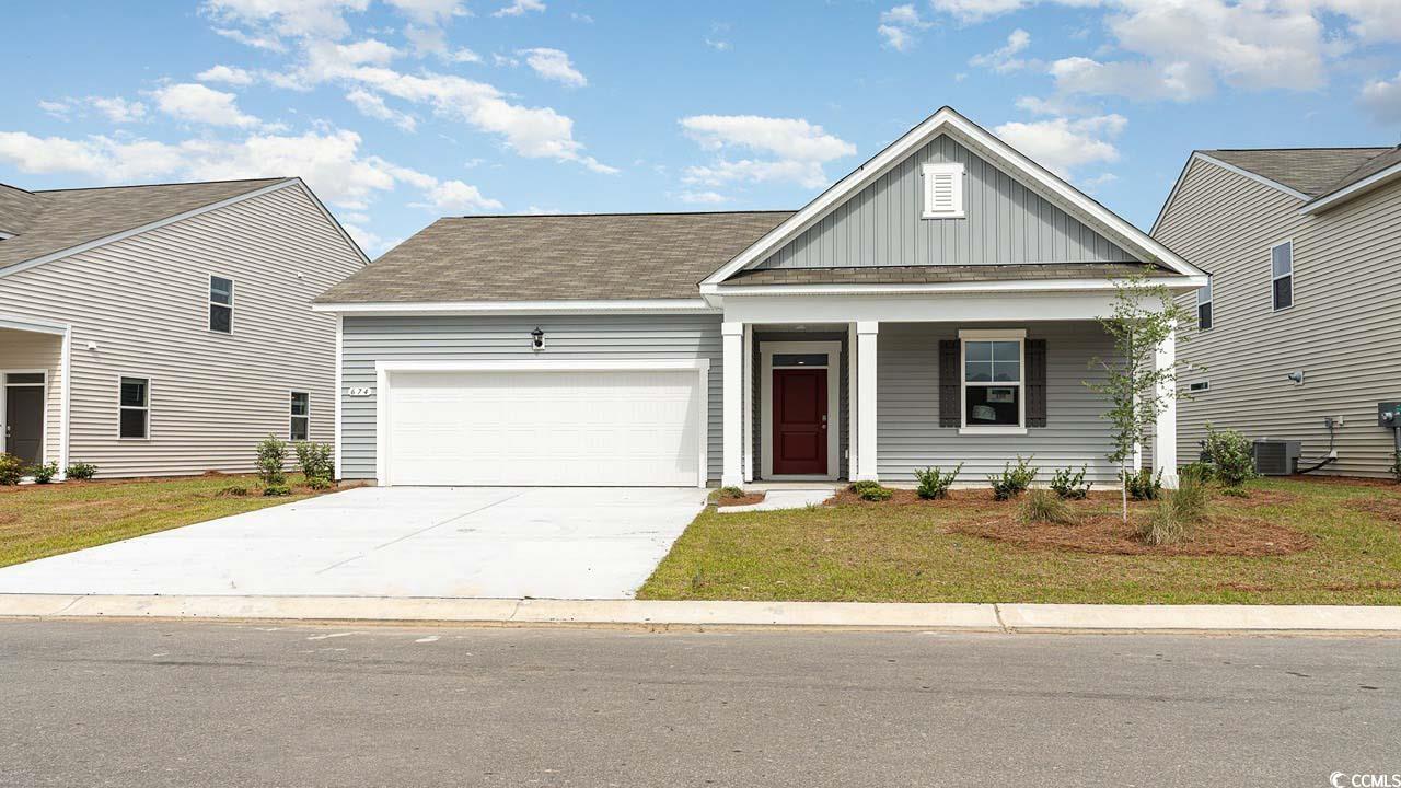 View of front of home with covered porch, a garage