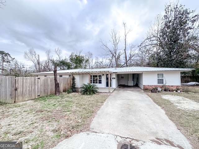 a view of a house with a yard and fence