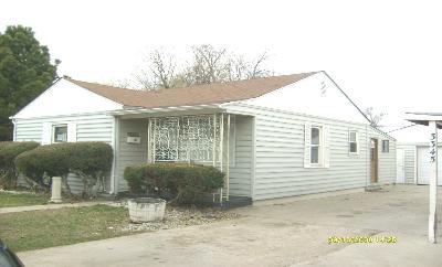 a view of a house with a yard and sitting area