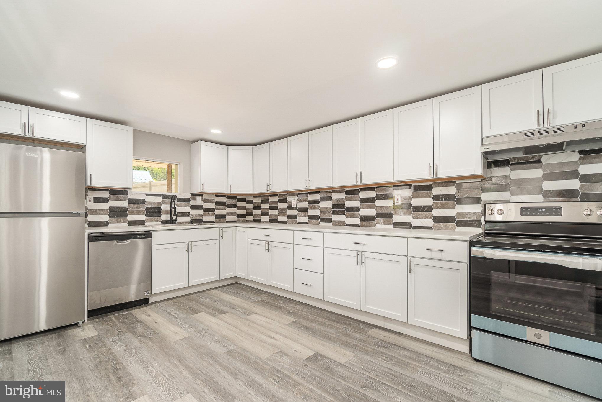 a kitchen with granite countertop white cabinets and white appliances