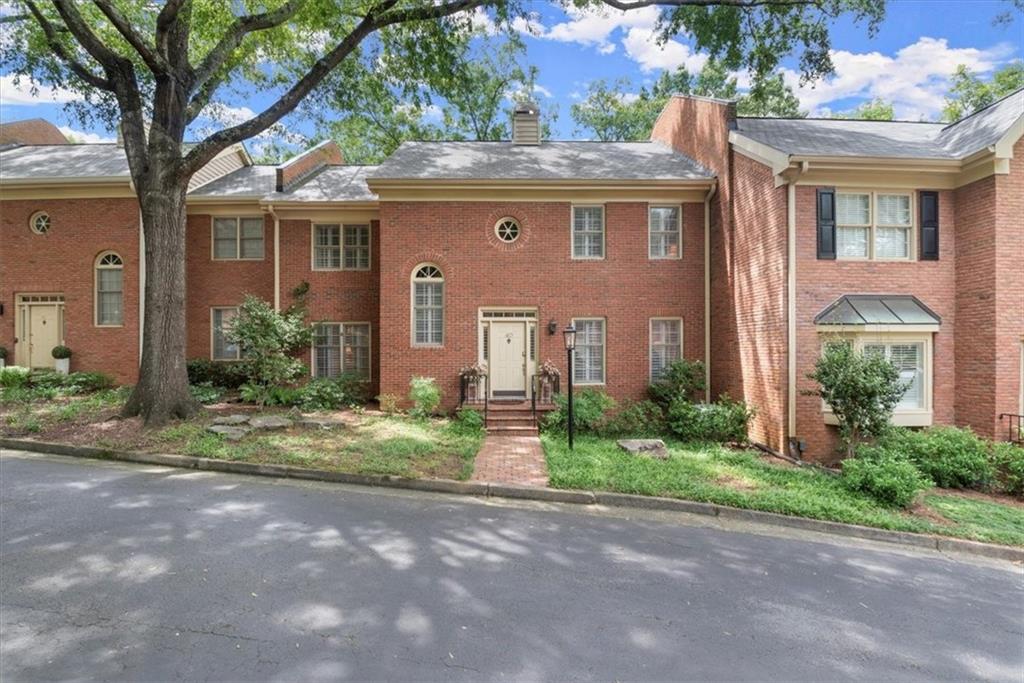 front view of a brick house with a yard