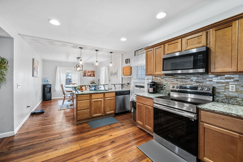 a kitchen with stainless steel appliances granite countertop wooden cabinets a stove top oven a sink and dishwasher