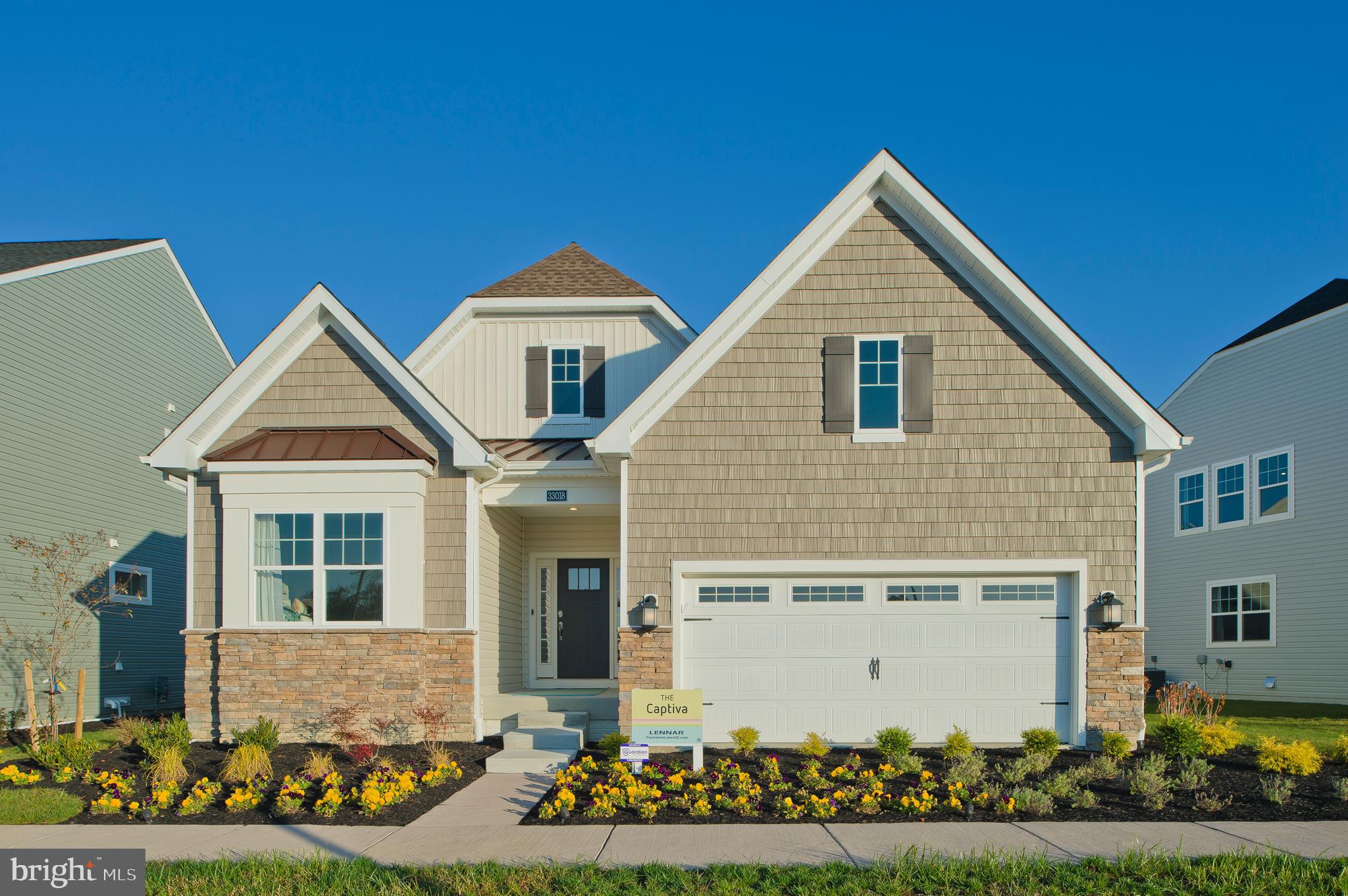 a front view of a house with a garden and plants