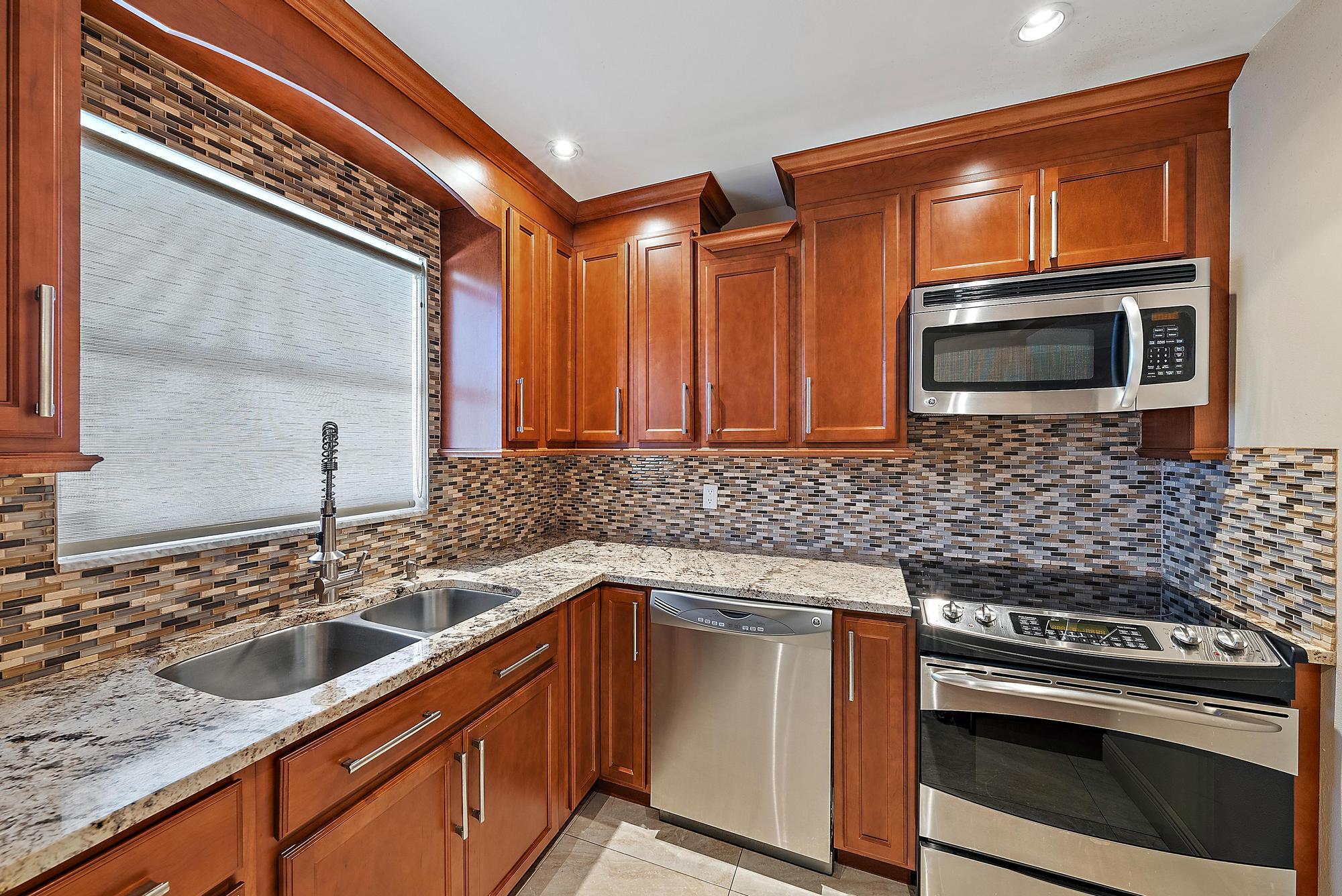 a kitchen with stainless steel appliances a stove sink and microwave