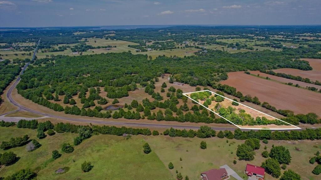 an aerial view of a residential houses with outdoor space and trees