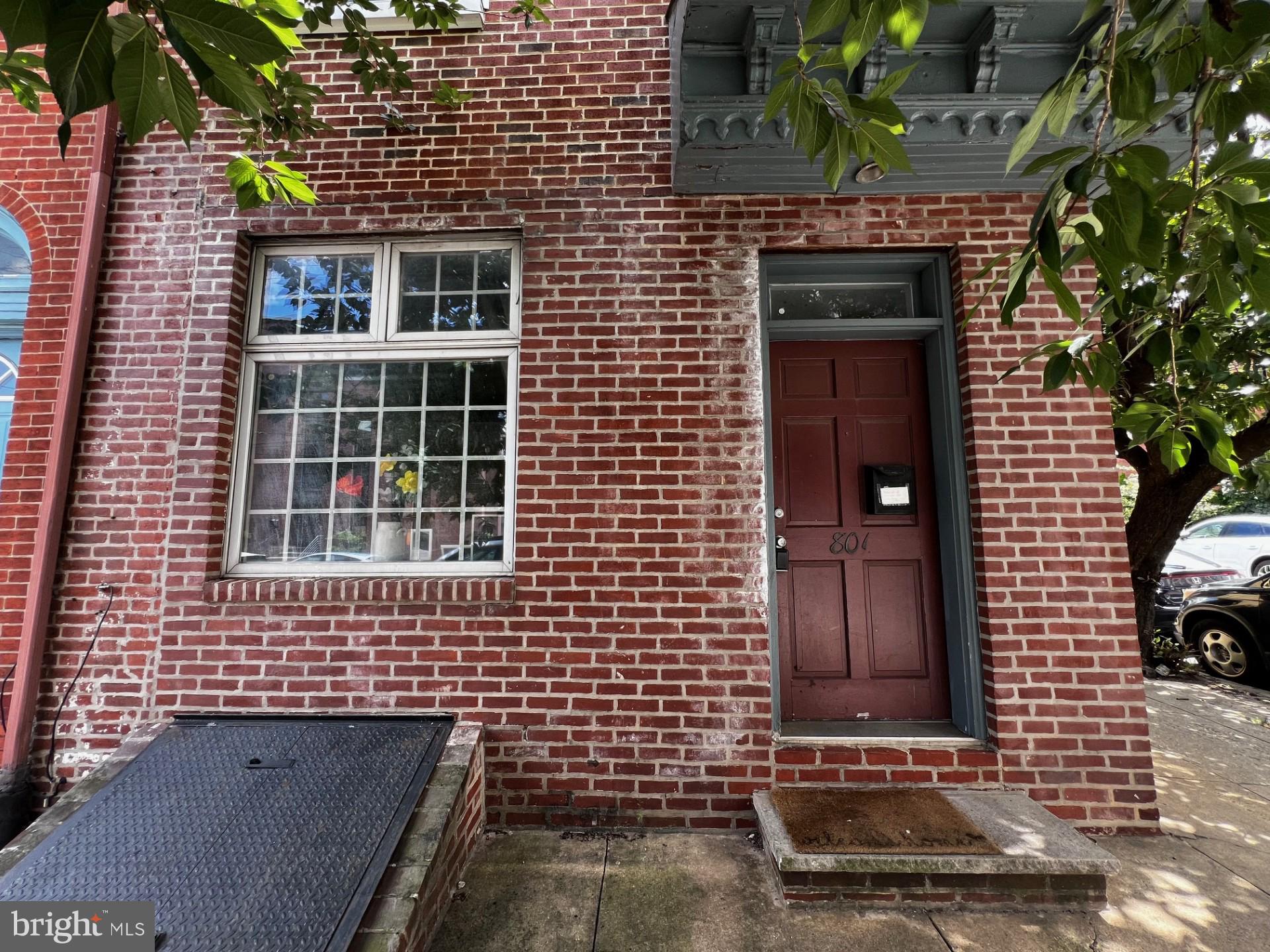 a brick house with a door and a potted plant