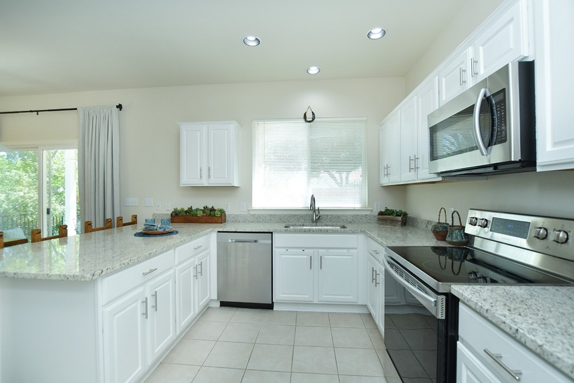 a kitchen with stainless steel appliances granite countertop a sink stove a microwave and cabinets