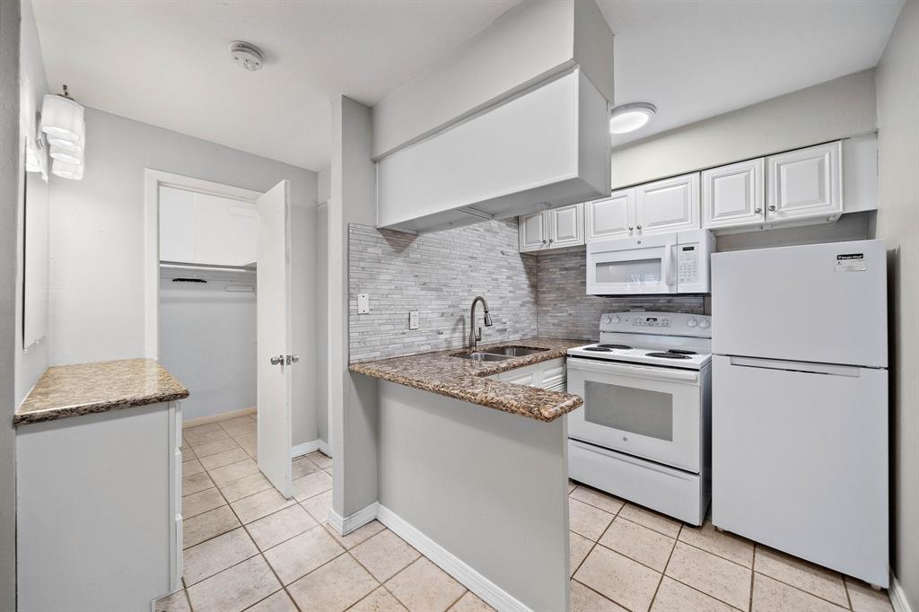 a kitchen with white cabinets and white appliances