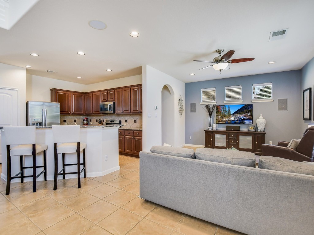 a living room with stainless steel appliances kitchen island granite countertop furniture and a view of kitchen