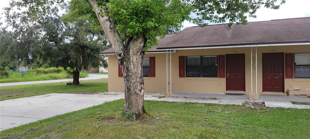 a view of a house with a tree and a yard