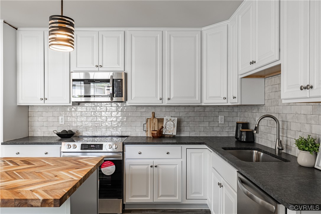 a kitchen with granite countertop a sink stainless steel appliances and cabinets