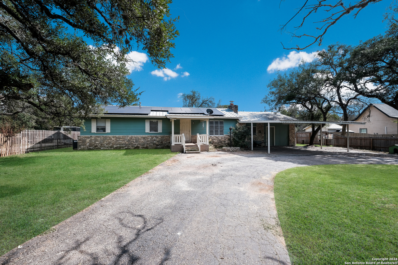 a front view of a house with a yard and trees