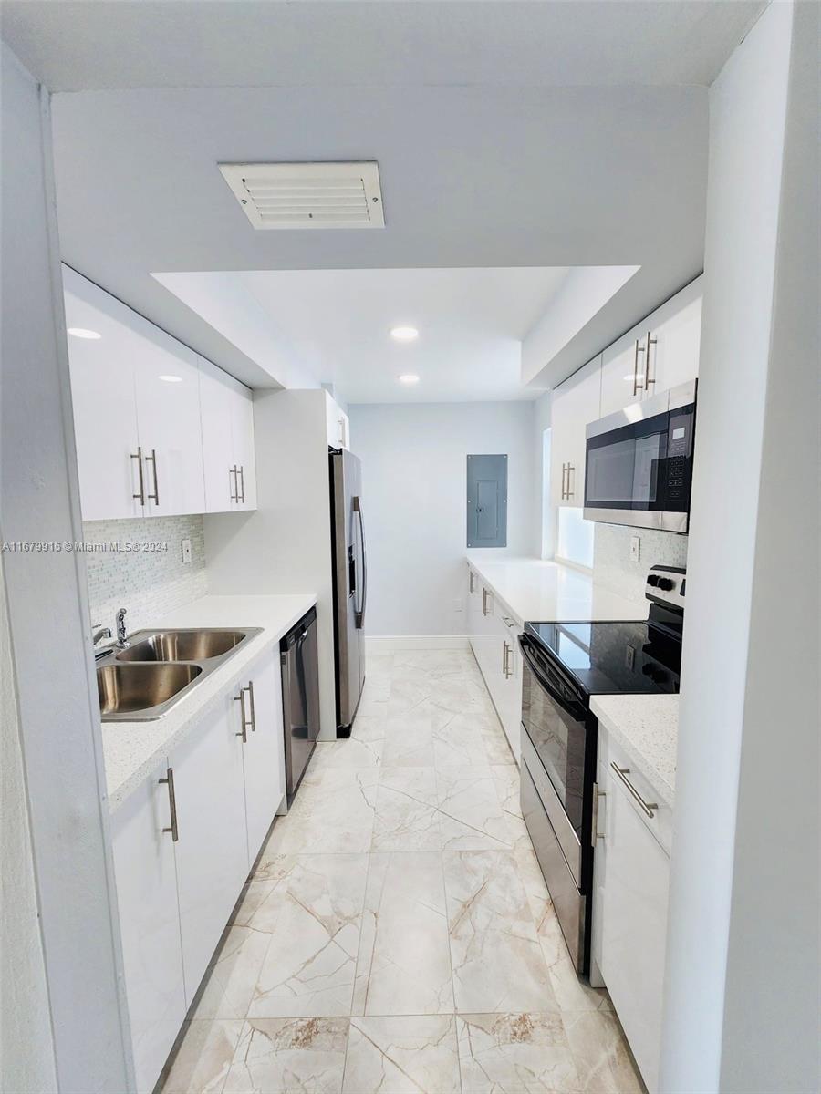 a kitchen with stainless steel appliances a sink stove and cabinets