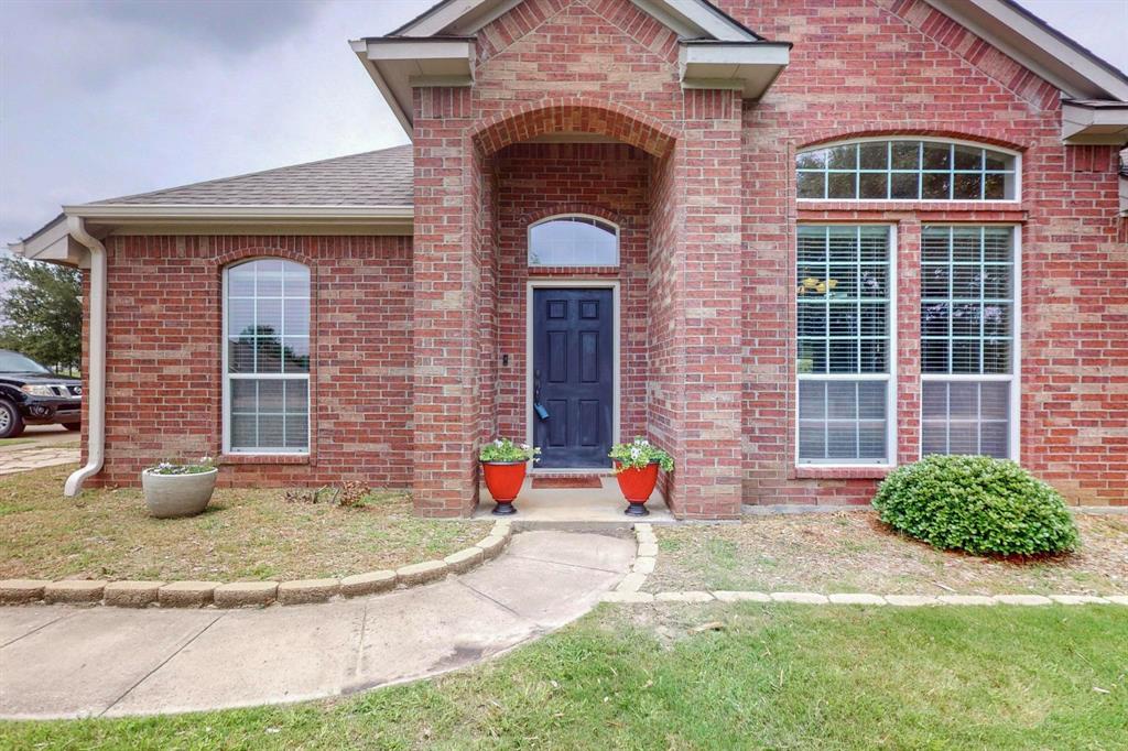 a view of a brick house with a small yard