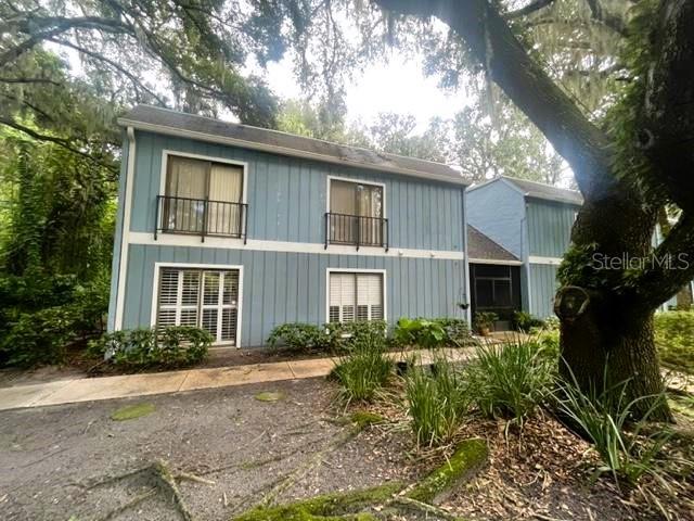 a front view of house with yard and trees around