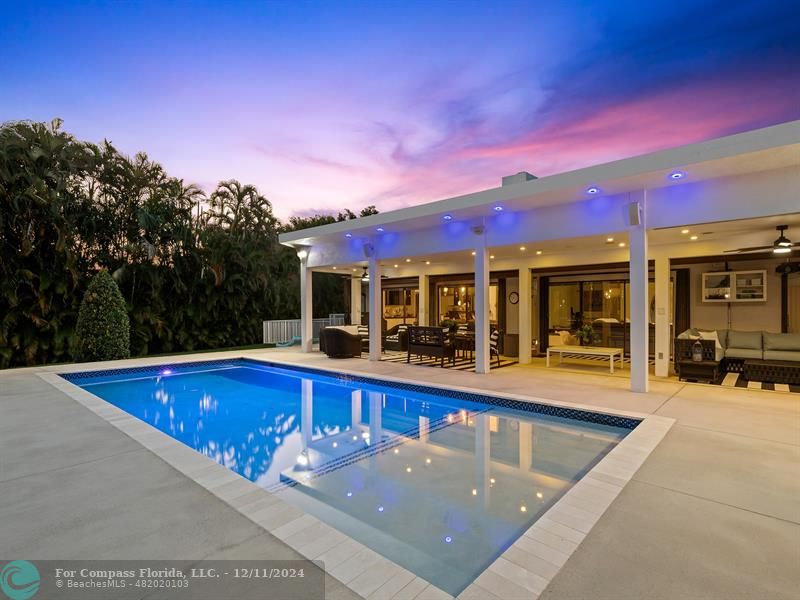 a view of a house with swimming pool and sitting area