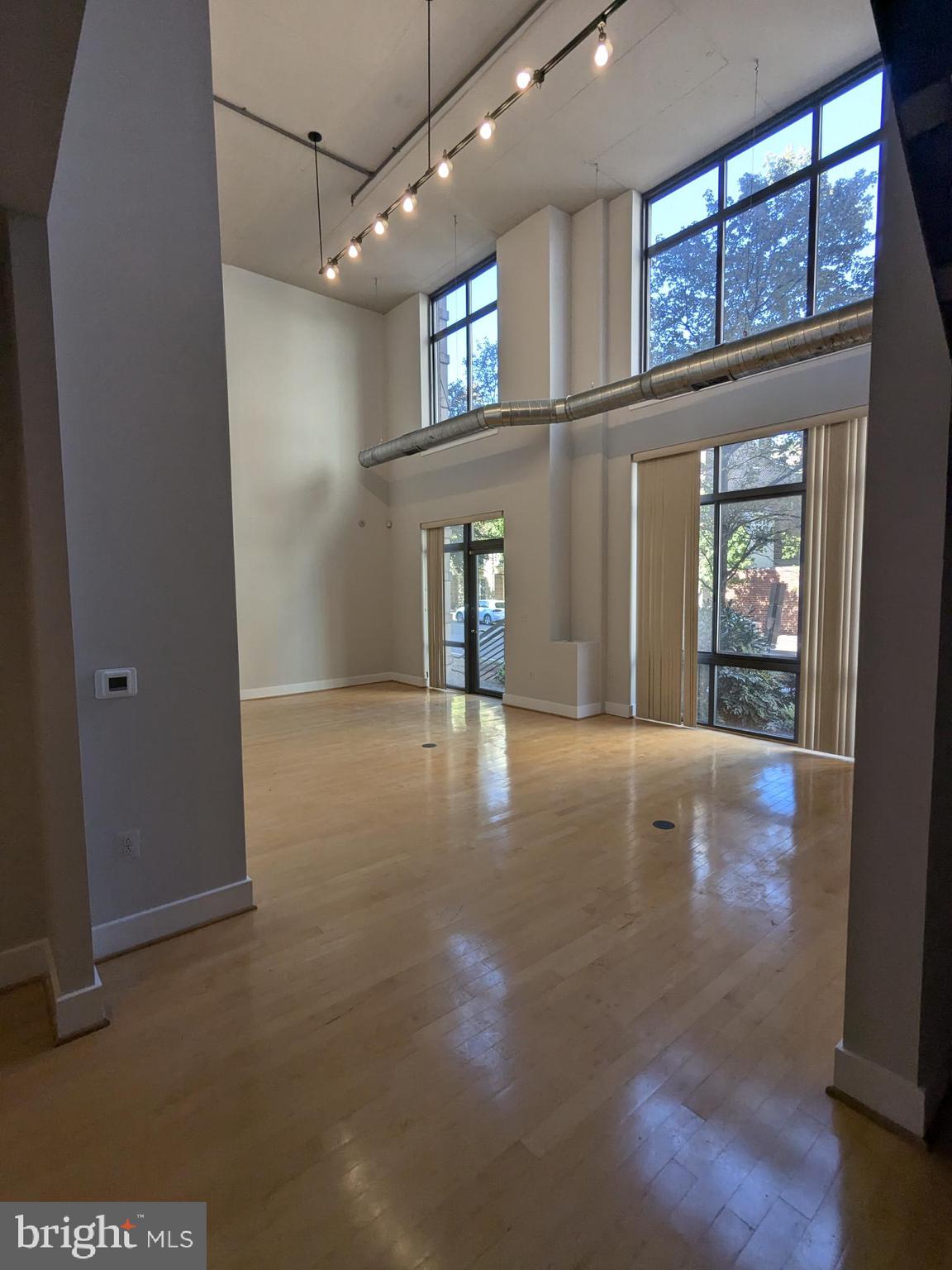 a view of a livingroom with wooden floor and a large window