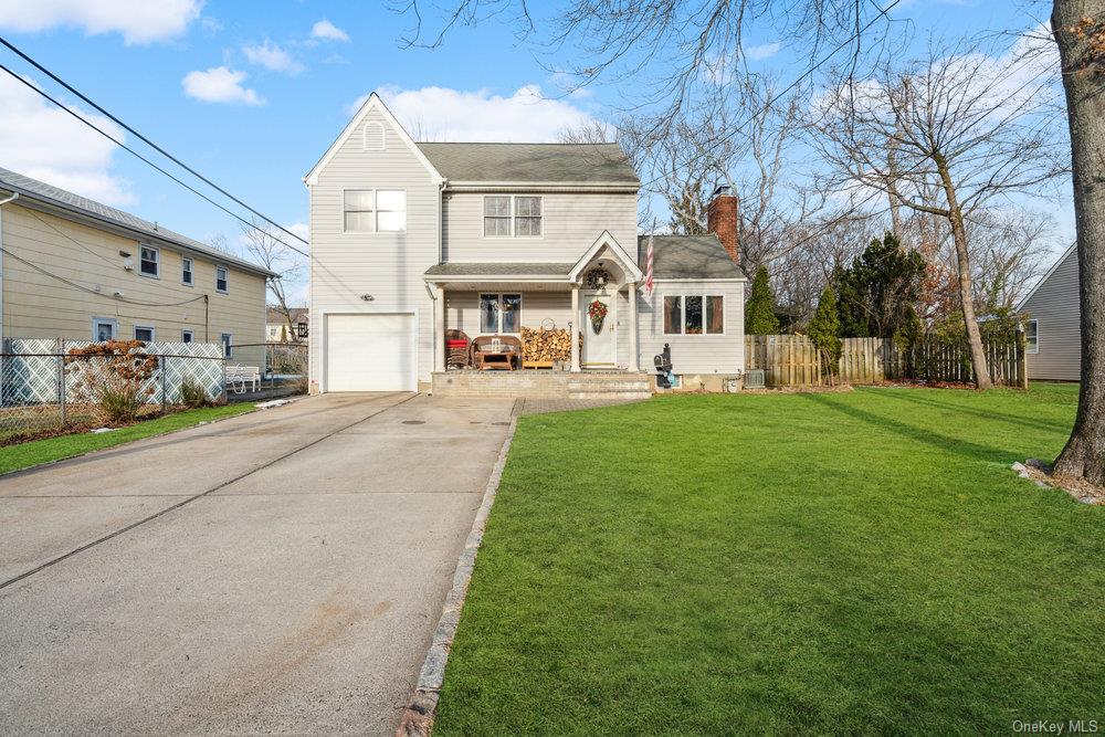 View of property featuring a front lawn and a garage