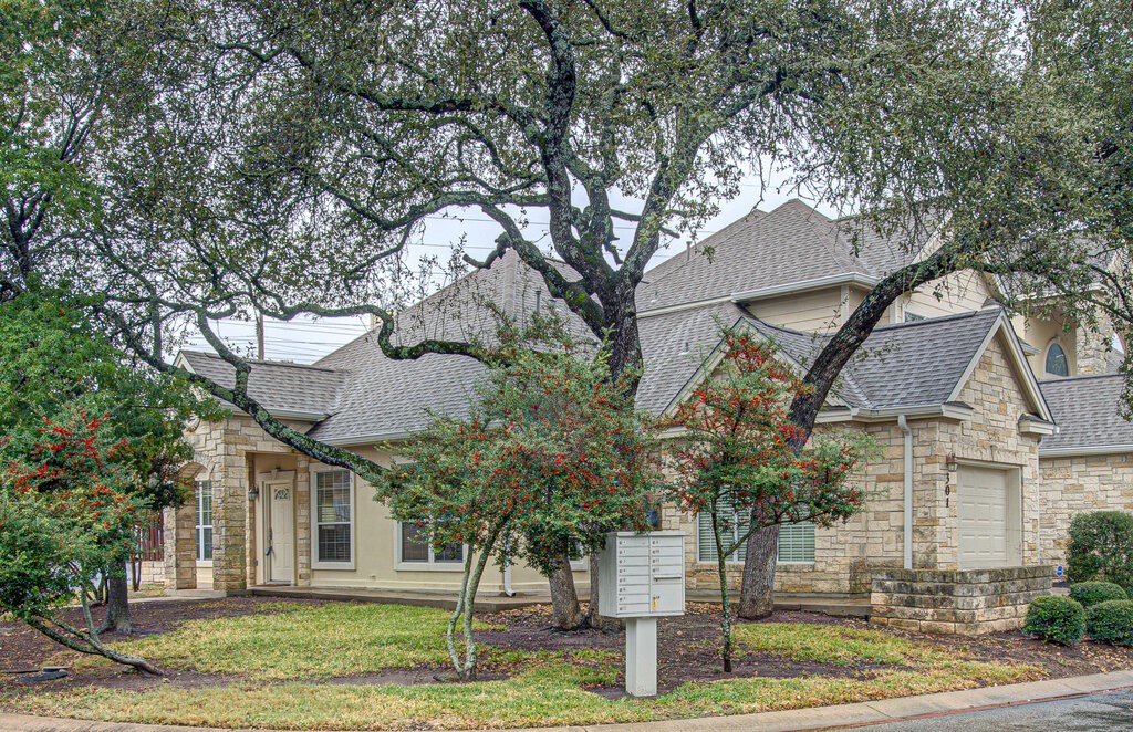 a front view of a house with a tree