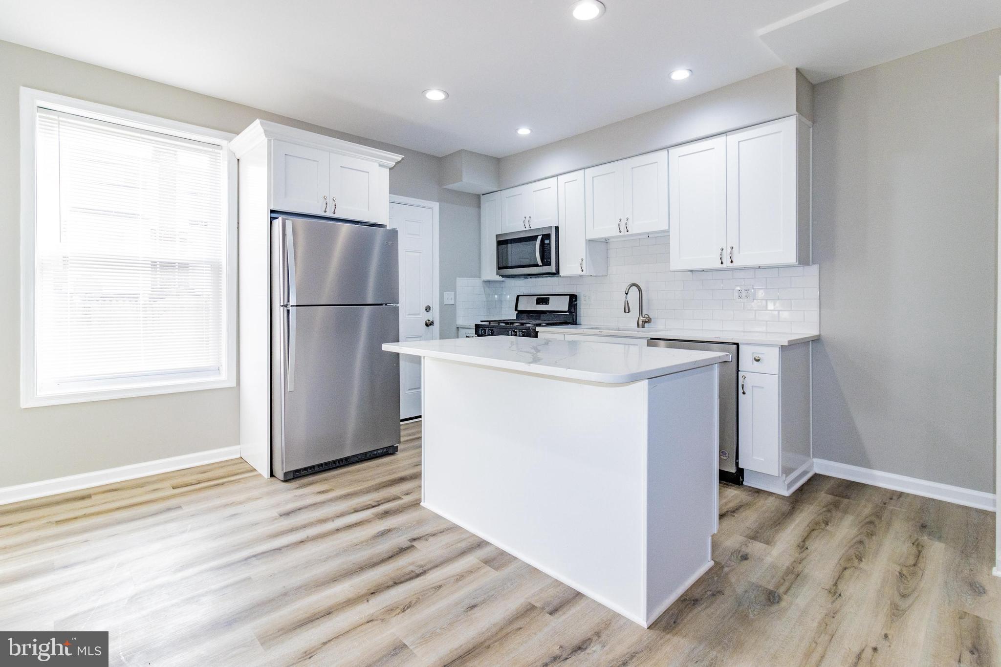 a kitchen with a refrigerator a sink and cabinets